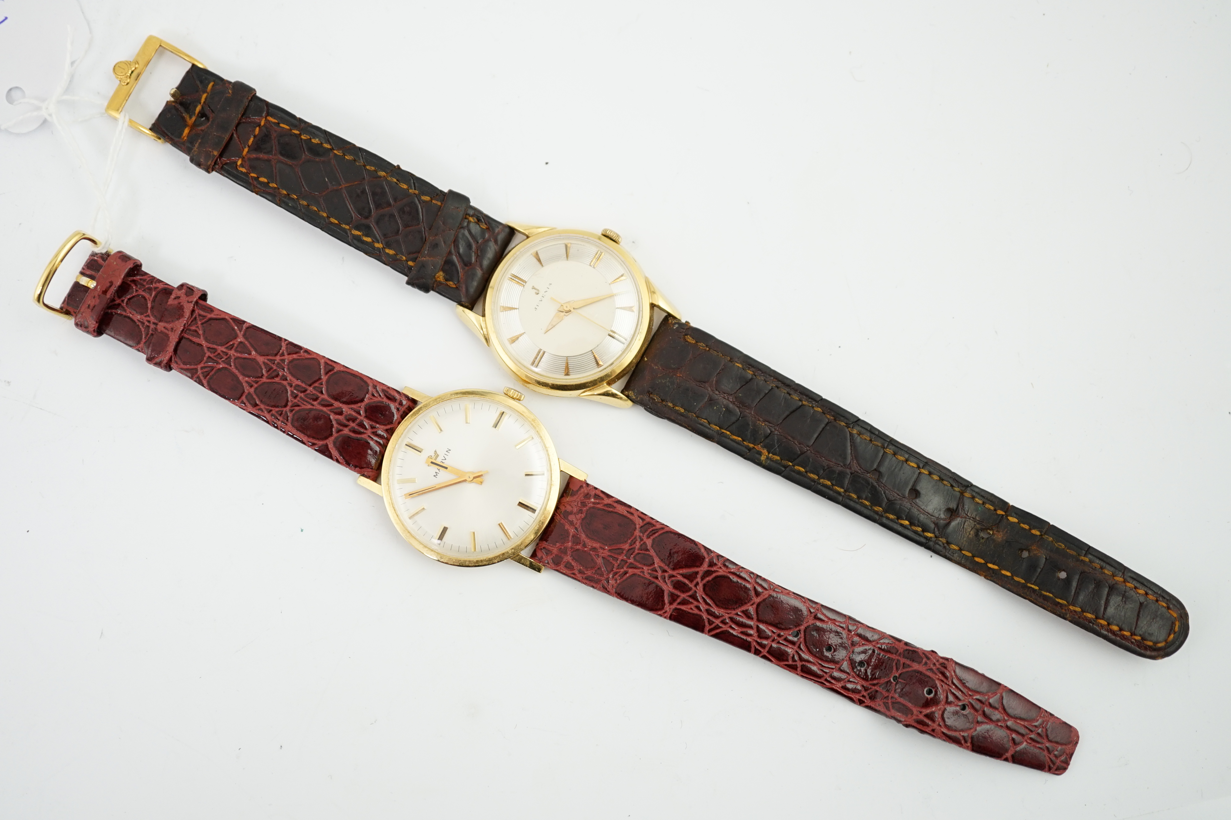 A gentleman's 1960's 18ct? gold Juvenia manual wind wrist watch, on a leather strap and a gentleman's 18ct? gold Marvin manual wind wrist watch, on a leather strap